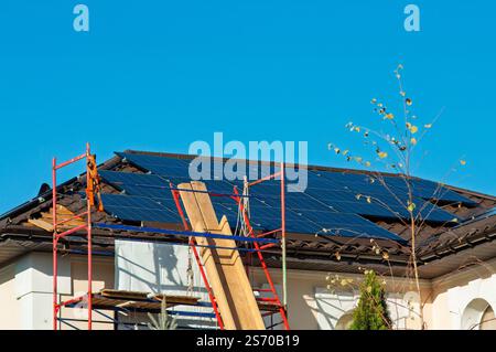 Allestimento di ponteggi per l'installazione di pannelli solari su un tetto residenziale. Foto Stock