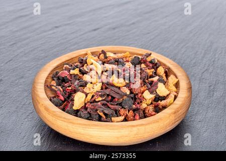 Tè profumato della foresta dei Carpazi con utensili in legno, macro. Foto Stock