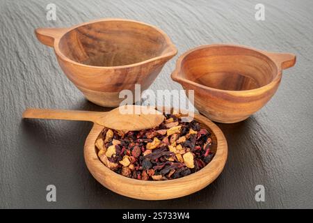 Tè profumato della foresta dei Carpazi con utensili in legno, macro. Foto Stock