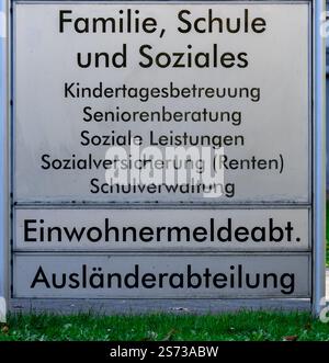 Un segno con scritto straniero. Il cartello è in bianco e nero. Il cartello è intitolato "famiglia, scuola e società" Foto Stock
