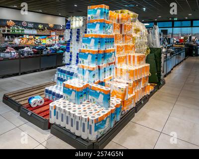 Fossano, Italia - 14 gennaio 2025: Rotoli di carta asciugamani e carta igienica in confezioni impilate su pallet in vendita al supermercato Aldi Foto Stock