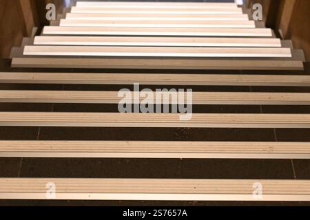 Vista ad angolo alto di una rampa di scale. Ogni gradino è dotato di una striscia antiscivolo. Foto Stock