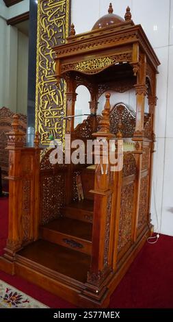 Un minbar in legno splendidamente lavorato, progettato con intagli ed elementi decorativi. Presenta una scala che porta ad una piattaforma, tipo Foto Stock
