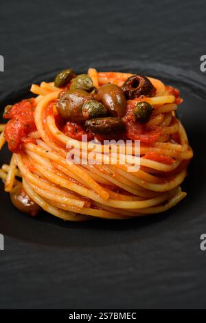 Spaghetti alla Puttanesca con salsa di pomodoro piccante con olive nere e Capperi Foto Stock