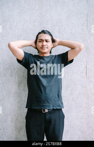 Uomo che soffre di mal di testa, che tiene la testa sotto frustrazione. Foto Stock