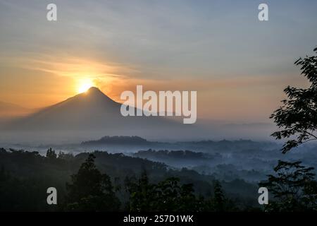 Alba su Borobudur nella nebbia mattutina e fumo del vulcano Merapi, Giava centrale, Indonesia Foto Stock