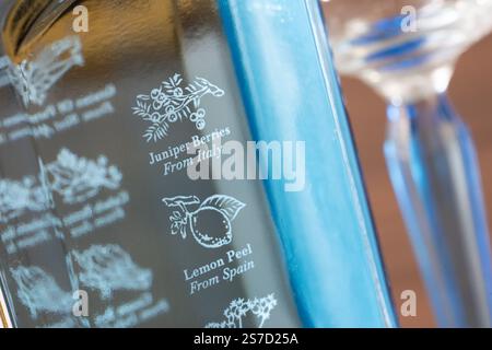 Iconica bottiglia blu di gin Bombay Sapphire con dieci ingredienti botanici e la loro origine incisa nel bicchiere, tra cui bacche di ginepro provenienti dall'Italia Foto Stock