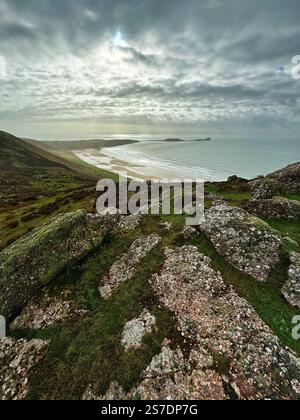 Vista da Rhossili Downs su Rhossili Bay verso Worms Head, Gower, Swansea, Galles. Foto Stock
