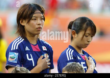 Le giocatrici della squadra giapponese Saki Kumagai (L) e Aya Sameshima (R) rappresentano l'inno nazionale prima di una partita di calcio dei quarti di finale della Coppa del mondo femminile FIFA contro la Germania il 9 luglio 2011 all'Arena Im Allerpark di Wolfsburg, Germania. Solo per uso editoriale. Uso commerciale vietato. Foto Stock