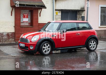 TOKAJ, UNGHERIA - 27 OTTOBRE 2023: Auto rossa Mini Cooper R56 parcheggiata in strada in caso di pioggia Foto Stock