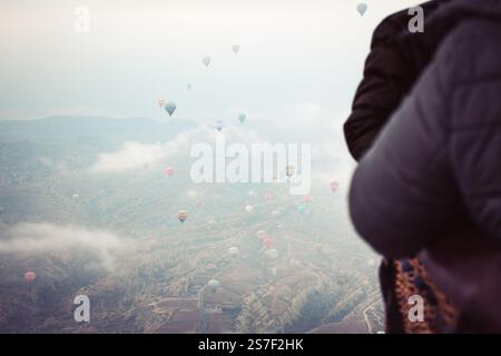 i passeggeri al decollo in mongolfiera godono di vedute delle valli kapadokya all'interno del cestino in mongolfiera in inverno. Volo in mongolfiera in Cappadocia Foto Stock