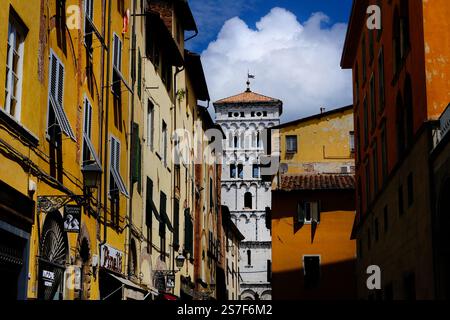 Via Beccheria, una via dello shopping nel centro storico di Lucca con alla fine il campanile medievale Foto Stock