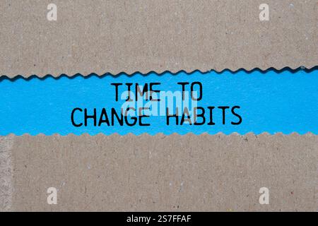Messaggio tempo per cambiare abitudini scritto su carta strappata su sfondo blu. Simbolo del tempo concettuale per cambiare le abitudini. Copia spazio. Foto Stock