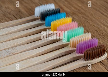 Set di spazzolini in bambù multicolore su sfondo in legno, primo piano. Zero sprechi, senza plastica, concetto di prodotto biologico ecologico Foto Stock