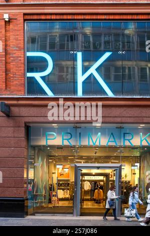 Shoopers Belfast fuori dal negozio di moda Primark Belfast. Nome Primark all'ingresso del negozio con la merce in mostra. Foto Stock