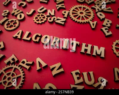 Primo piano parola in legno e attrezzatura in legno con la parola ALGROITHM su sfondo rosso. Foto Stock