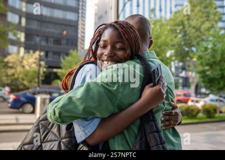 Tanto atteso incontro di coppia afroamericana e ragazzi con sorrisi, abbracci per camminare insieme Foto Stock