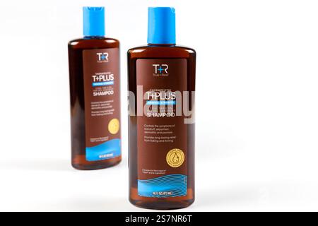 Le bottiglie dello shampoo sono disposte su una superficie pulita con un design minimalista e una luce intensa Foto Stock