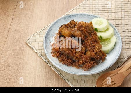 Ayam Goreng Lengkuas, pollo fritto cotto con spezie e cosparso di galangal grattugiato. Cibo tradizionale indonesiano. Foto Stock