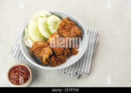 Ayam Goreng Lengkuas, pollo fritto cotto con spezie e cosparso di galangal grattugiato. Cibo tradizionale indonesiano. Foto Stock