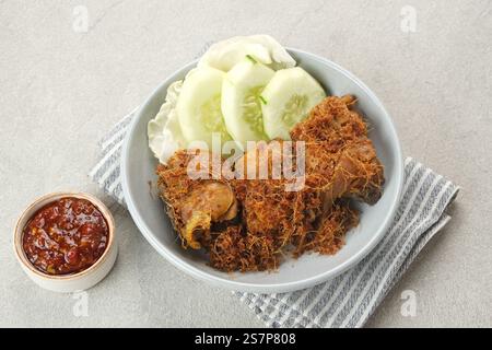 Ayam Goreng Lengkuas, pollo fritto cotto con spezie e cosparso di galangal grattugiato. Cibo tradizionale indonesiano. Foto Stock