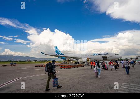 I passeggeri salgono a bordo di un volo Air Transat dall'asfalto all'aeroporto di Port-au-Prince. Un momento di resilienza e speranza per i viaggiatori. Foto Stock