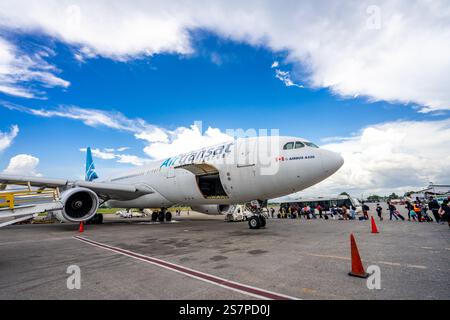 I passeggeri salgono a bordo di un volo Air Transat dall'asfalto all'aeroporto di Port-au-Prince. Un momento di resilienza e speranza per i viaggiatori. Foto Stock