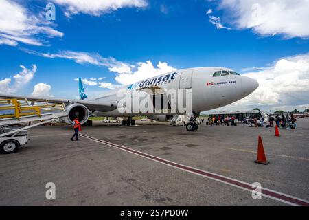 I passeggeri salgono a bordo di un volo Air Transat dall'asfalto all'aeroporto di Port-au-Prince. Un momento di resilienza e speranza per i viaggiatori. Foto Stock