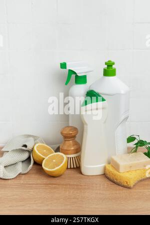 Prodotti per la pulizia eco-compatibili disposti su un piano di lavoro in legno, che incarnano una pulizia sostenibile con prodotti naturali ed ecologici Foto Stock