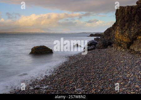Onde che si infrangono su una spiaggia di ghiaia a Ganavan, vicino Oban, West Highland, Scozia, Regno Unito. Foto Stock