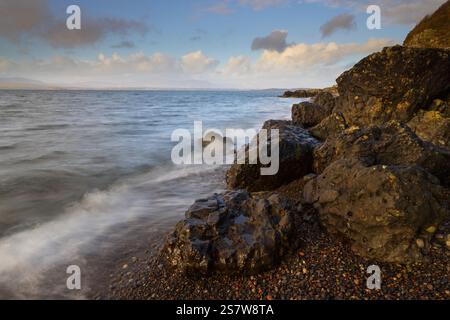 Onde che si infrangono su una spiaggia di ghiaia a Ganavan, vicino Oban, West Highland, Scozia, Regno Unito. Foto Stock