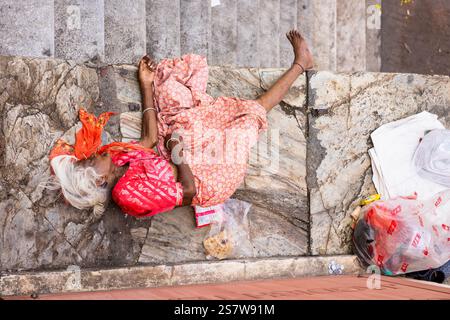 Povera donna anziana che dorme per strada, Udaipur, Rajasthan, India Foto Stock