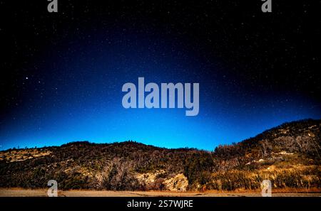 Cielo stellato sopra la catena montuosa illuminato dalla luce della luna, astrofotografia sopra la catena montuosa, vista panoramica notturna Foto Stock