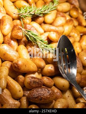 patate intere cotte nel forno e un rametto di rasmarina. Foto di alta qualità Foto Stock