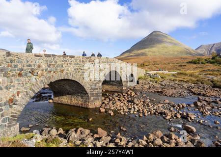 Sligachan Skye - persone che camminano attraverso il vecchio ponte di Sligachan sul fiume Sligachan sull'Isola di Skye Highlands e isole Scozia Regno Unito Europa Foto Stock
