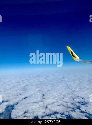 Vista da un posto vicino al finestrino su un volo Spirit Airlines, che mostra l'ala dell'aereo con scritto "Howdy" sullo sfondo di cieli limpidi. Un un Foto Stock