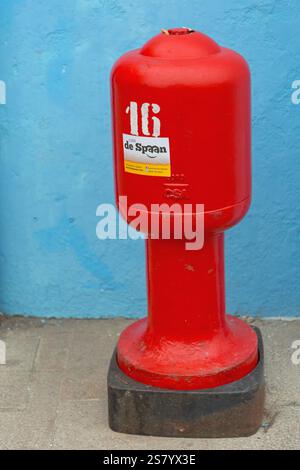 Venezia, Italia - 10 gennaio 2017: Red Fire Hydrant presso Street Blue House a Burano Island Winter Day Travel. Foto Stock