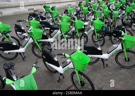 Noleggio di biciclette elettriche in calce sul marciapiede, Parliament Square, Westminster, Londra, Regno Unito. 18 gennaio 2025 Foto Stock