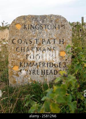 Un'importante insegna in pietra si trova lungo il sentiero costiero a Purbeck, nel Dorset, che presenta distanze da luoghi vicini, tra cui Kingston e Chapmans Pool Foto Stock