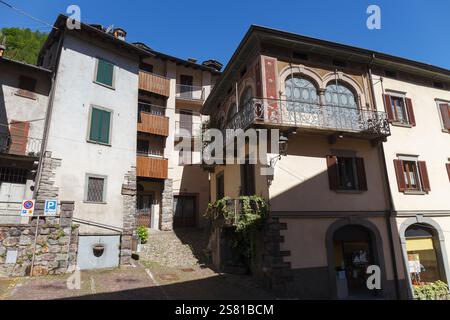 GROMO, ITALIA - 22 MAGGIO 2024: Vista su strada del villaggio storico con le strette strade acciottolate, girato alla luce dell'estate Foto Stock