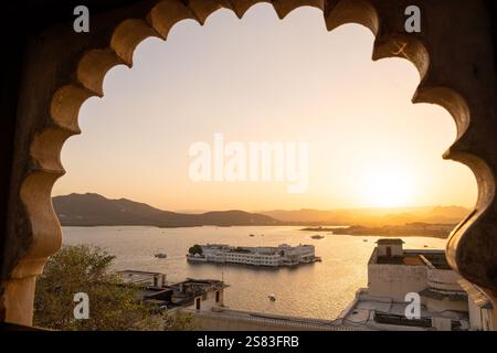 Vista dalla finestra del forte cittadino di Udaipur sul lago Pichola al tramonto nel Rajasthan, India Foto Stock