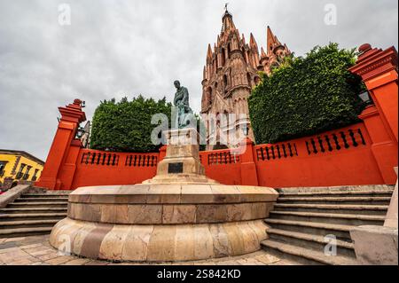 Chiesa storica e Monumento nella vivace Plaza sotto i cieli nuvolosi Foto Stock