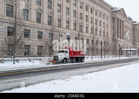 Una nevicata pulisce la neve al mattino sulla 15th Street NW di fronte all'edificio Herbert C. Hoover. È stata la più grande tempesta di neve della città degli ultimi anni. Foto Stock