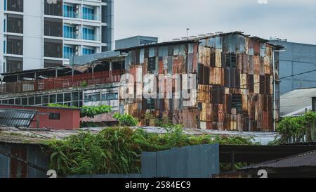 Balikpapan, Indonesia - 25 dicembre 2024. Una facciata di un edificio intempestivo con un mosaico di lamiere arrugginite. La foto mostra l'esclusivo testo Foto Stock