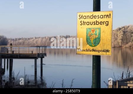 Un cartello per lo Standesamt Strausberg (Ufficio del Registro) vicino a Straussee, che indica un luogo per matrimoni con una vista panoramica sul lago in un giorno ghiacciato d'inverno. Foto Stock