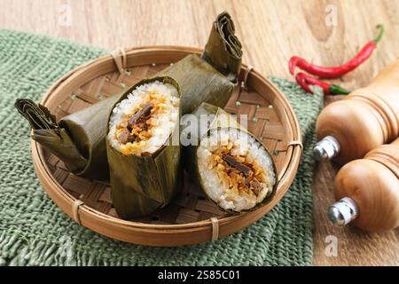 Arem-arem, un tradizionale cibo indonesiano a base di riso ripieno di verdure, pollo, carne o tempeh avvolti in foglie di banana. Foto Stock