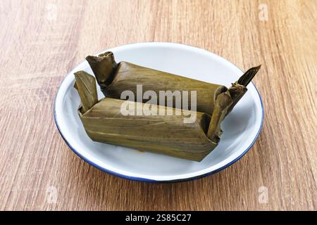 Arem-arem, un tradizionale cibo indonesiano a base di riso ripieno di verdure, pollo, carne o tempeh avvolti in foglie di banana. Foto Stock