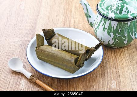 Arem-arem, un tradizionale cibo indonesiano a base di riso ripieno di verdure, pollo, carne o tempeh avvolti in foglie di banana. Foto Stock