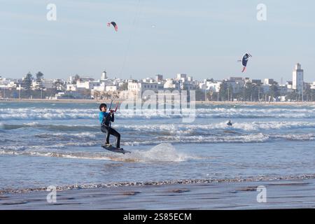Kite Surfers in mare con la storica Medina alle spalle nella città di Essaouira, in Marocco. 20 gennaio 2025 Foto Stock