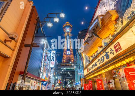 Vista della Torre Tsutenkaku e dei ristoranti con luci al neon al crepuscolo nell'area di Shinsekai, Osaka, Honshu, Giappone Foto Stock